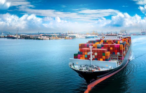 Aerial side view of cargo ship carrying container and running for export